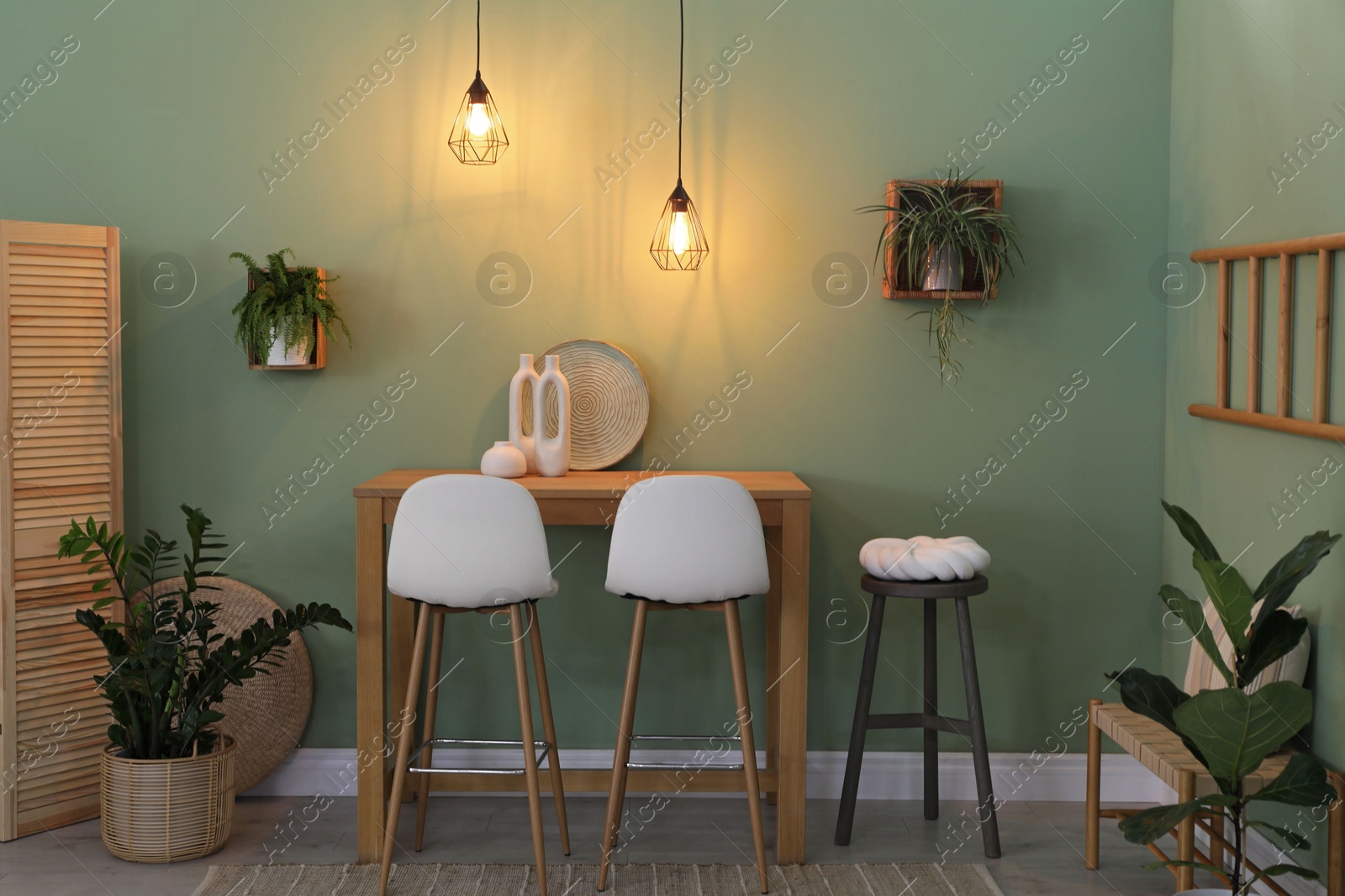 Photo of Bar stools, table and plants in room. Stylish interior design