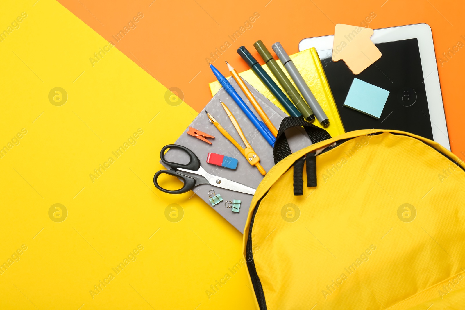 Photo of School backpack, tablet and stationery on color background, flat lay. Space for text