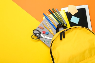 School backpack, tablet and stationery on color background, flat lay. Space for text