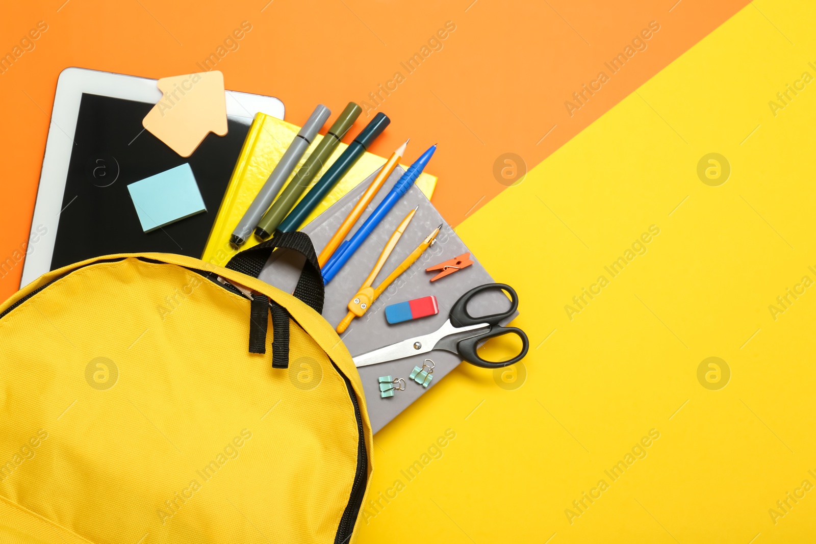 Photo of School backpack, tablet and stationery on color background, flat lay. Space for text