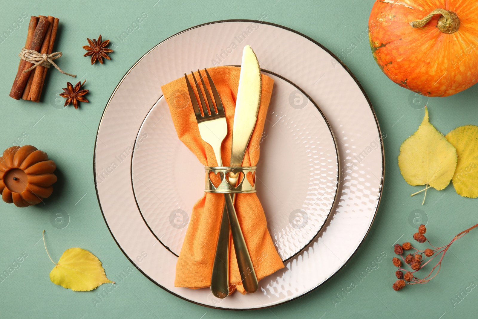 Photo of Beautiful table setting with autumn decor on turquoise background, flat lay