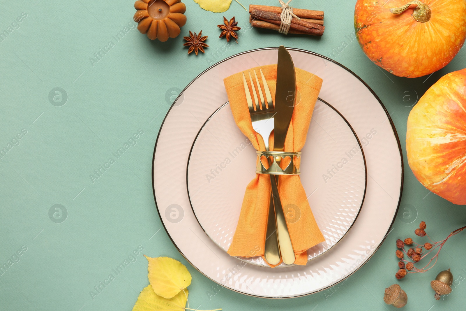 Photo of Beautiful table setting with autumn decor on turquoise background, flat lay. Space for text