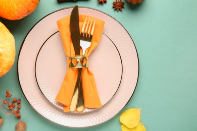 Photo of Beautiful table setting with autumn decor on turquoise background, flat lay. Space for text