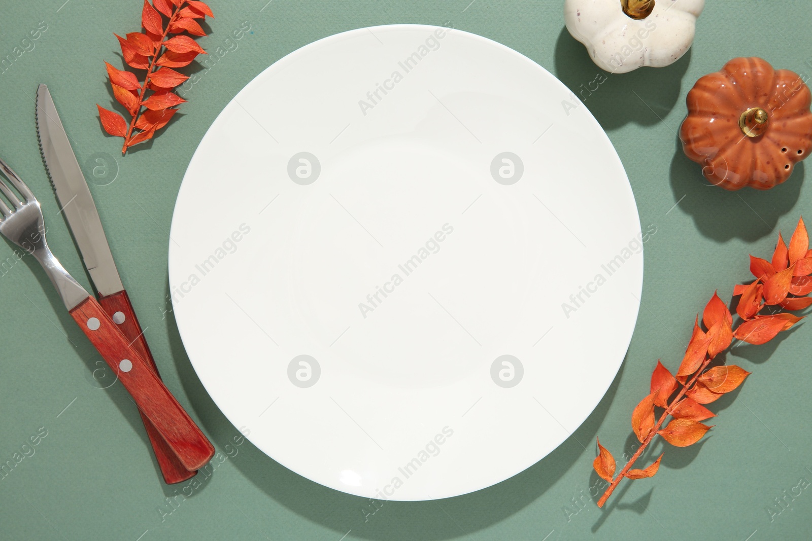 Photo of Beautiful table setting with autumn decor on turquoise background, flat lay