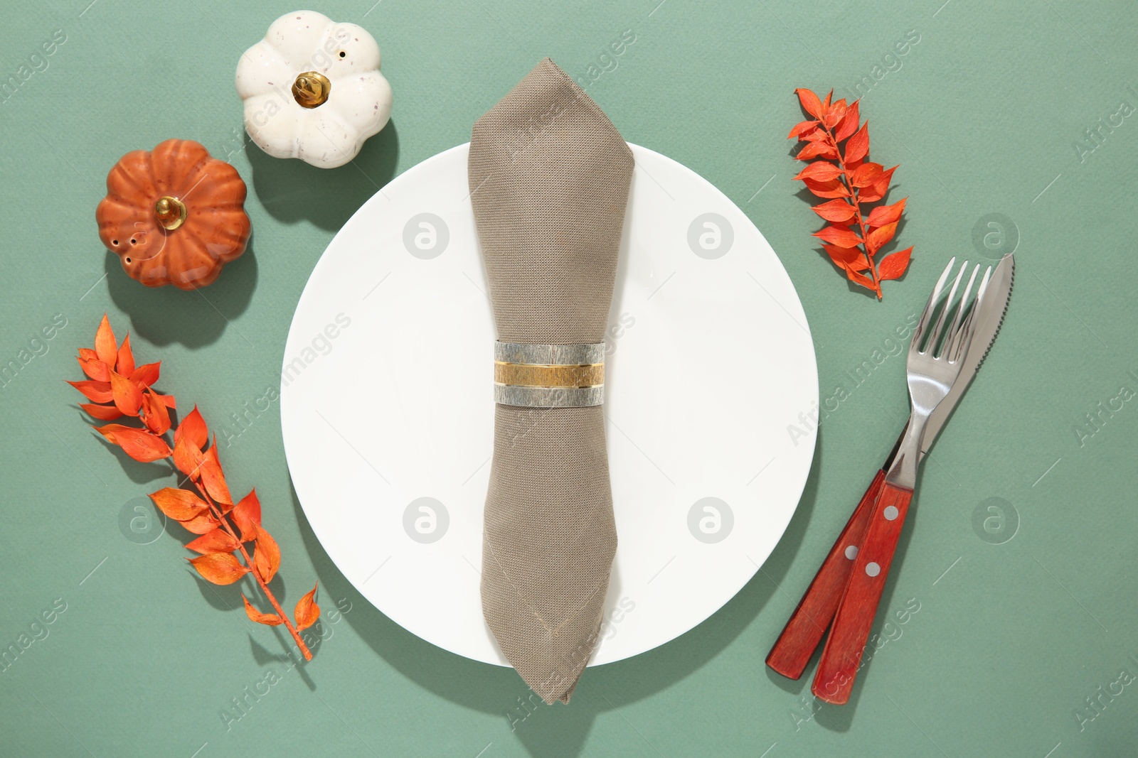 Photo of Beautiful table setting with autumn decor on turquoise background, flat lay