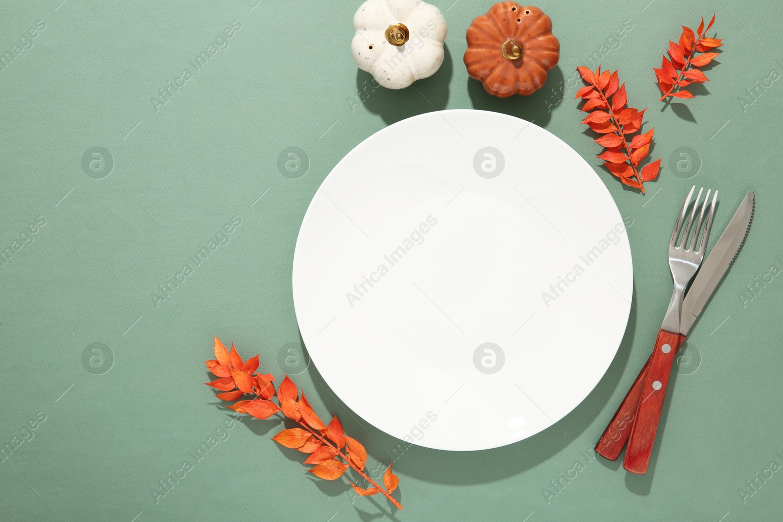 Photo of Beautiful table setting with autumn decor on turquoise background, flat lay. Space for text