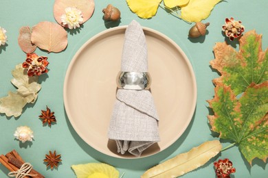 Beautiful table setting with autumn decor on turquoise background, flat lay