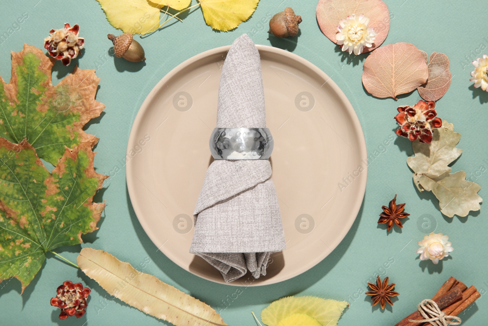 Photo of Beautiful table setting with autumn decor on turquoise background, flat lay