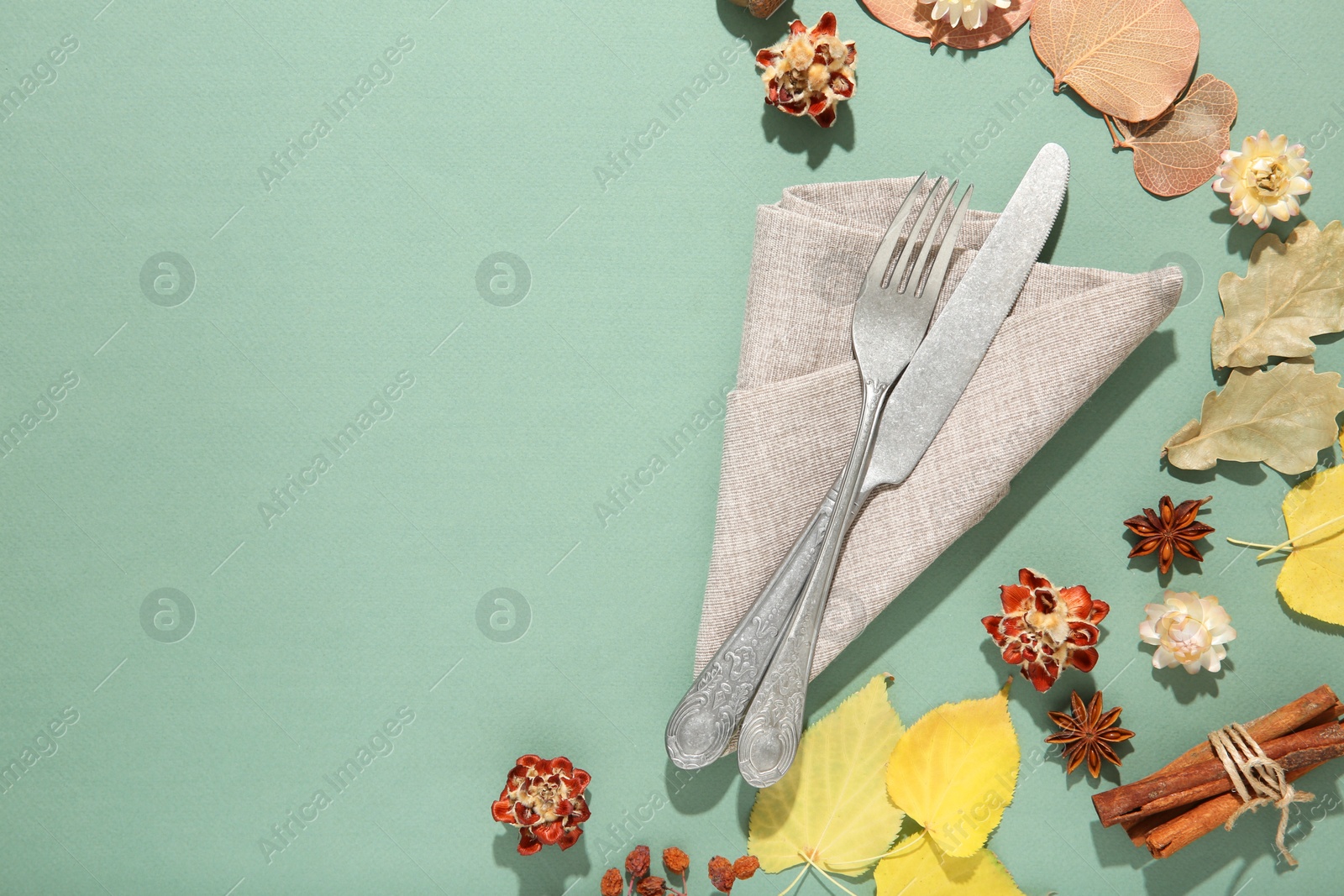 Photo of Beautiful table setting with autumn decor on turquoise background, flat lay. Space for text