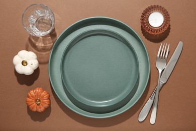 Beautiful table setting with autumn decor on brown background, flat lay