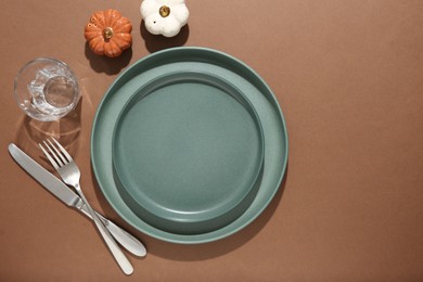 Photo of Beautiful table setting with autumn decor on brown background, flat lay. Space for text