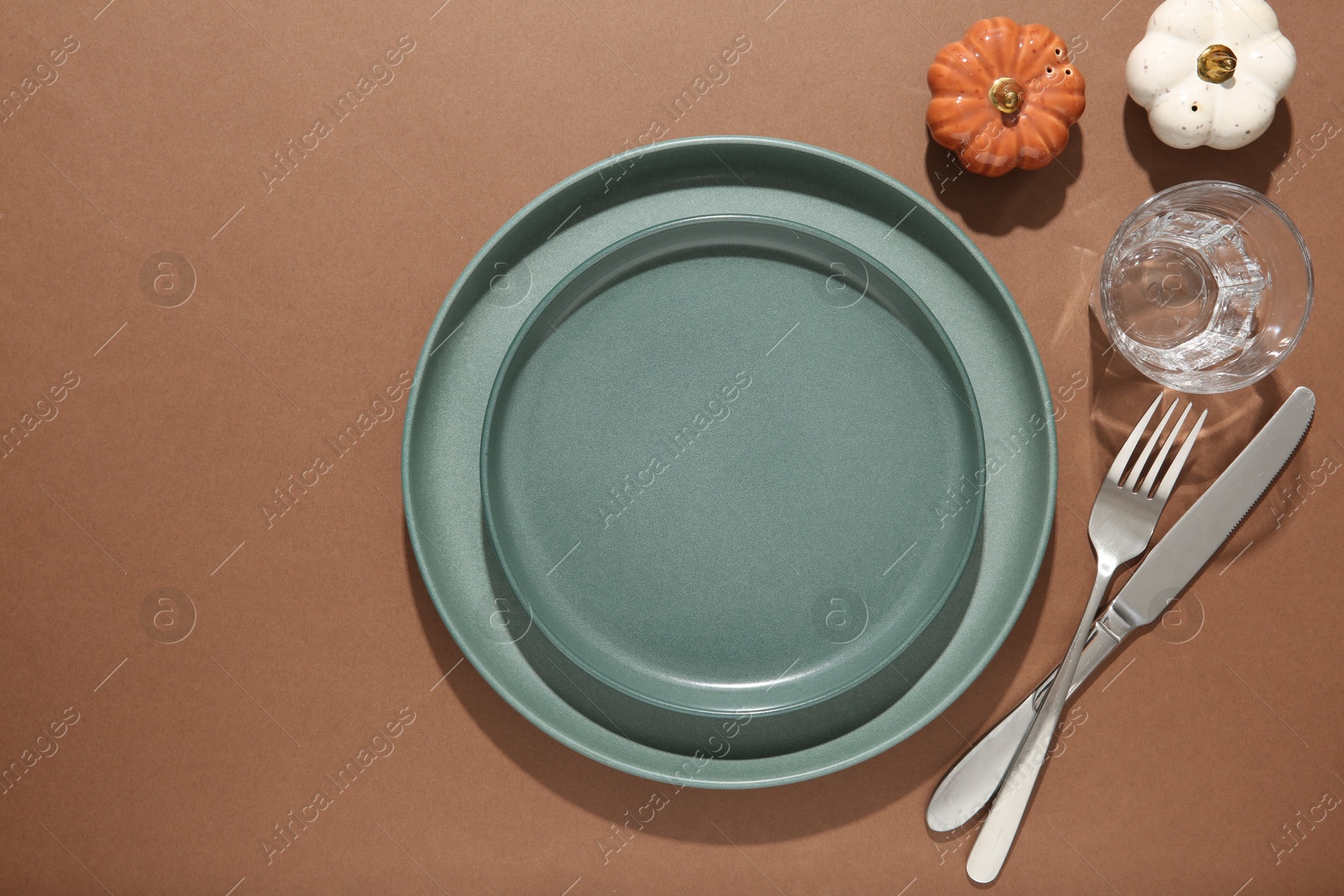 Photo of Beautiful table setting with autumn decor on brown background, flat lay. Space for text