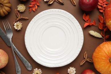 Photo of Beautiful table setting with autumn decor on brown background, flat lay