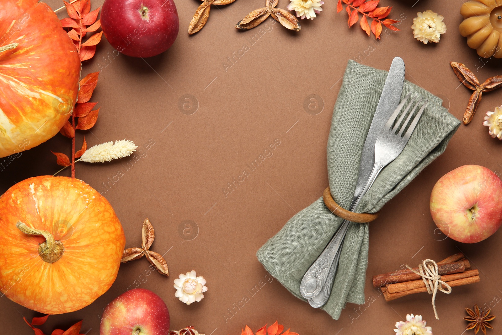 Photo of Frame made of beautiful table setting with autumn decor on brown background, flat lay. Space for text