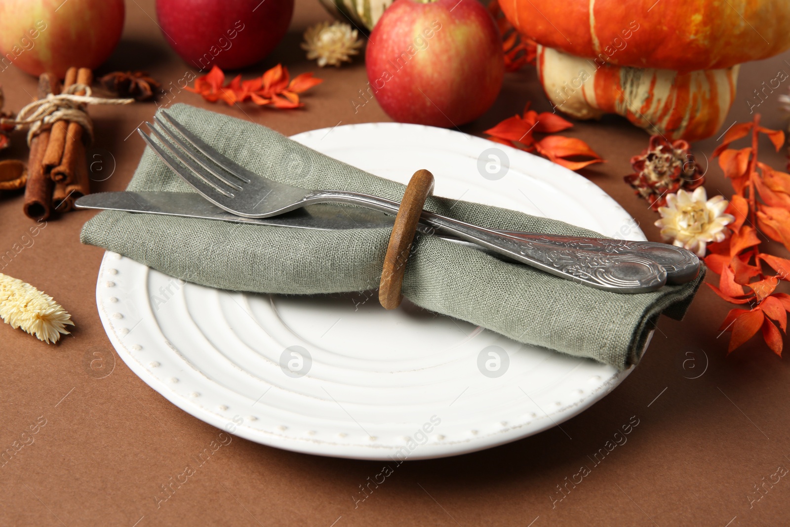 Photo of Beautiful table setting with autumn decor on brown background