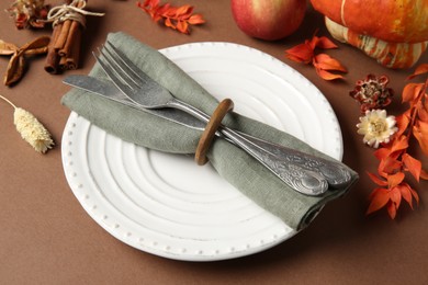 Photo of Beautiful table setting with autumn decor on brown background