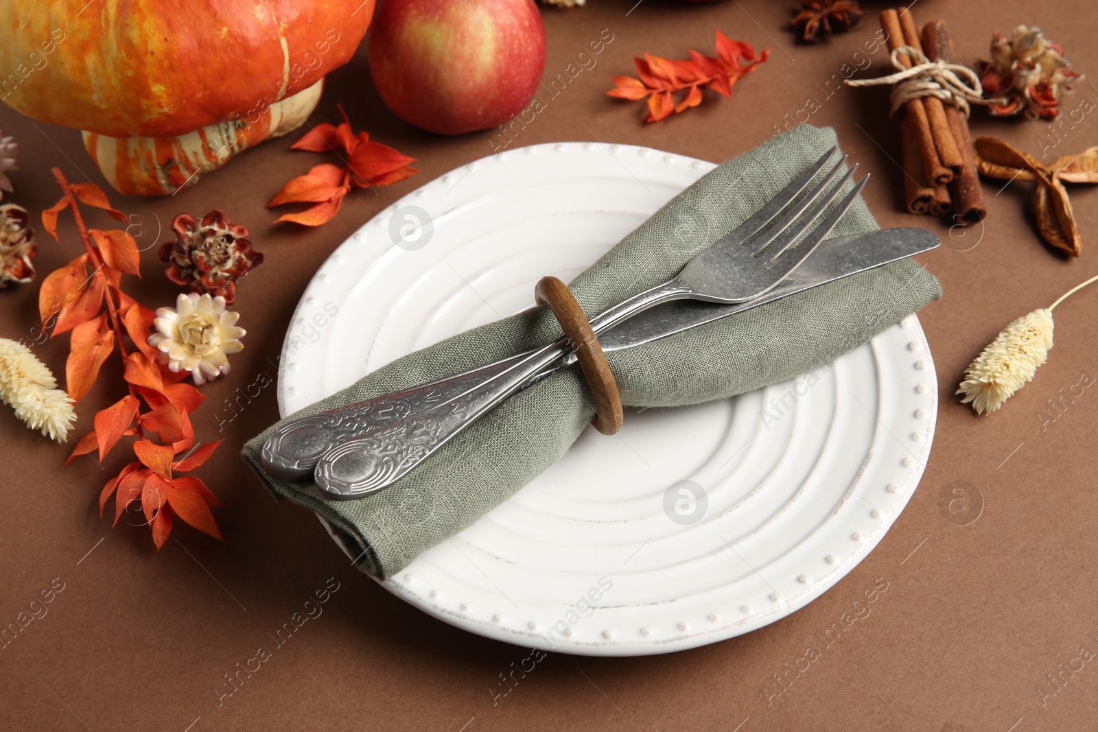 Photo of Beautiful table setting with autumn decor on brown background