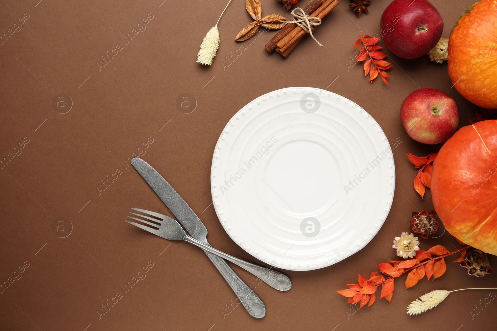 Photo of Beautiful table setting with autumn decor on brown background, flat lay. Space for text