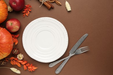 Photo of Beautiful table setting with autumn decor on brown background, flat lay