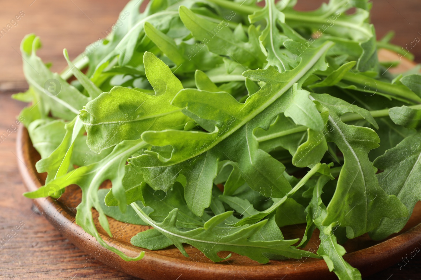 Photo of Fresh green arugula leaves on table, closeup