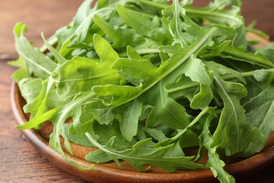 Photo of Fresh green arugula leaves on table, closeup