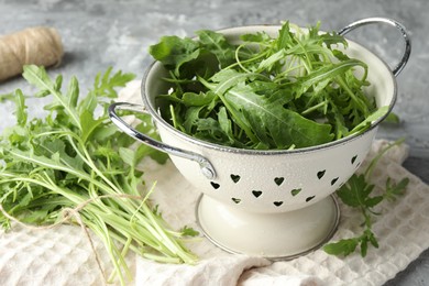 Photo of Fresh green arugula leaves on grey table