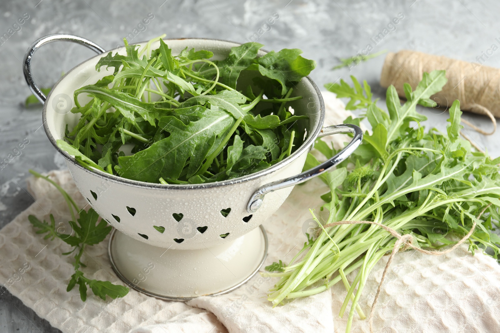 Photo of Fresh green arugula leaves on grey table