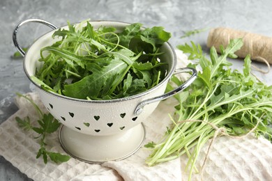 Photo of Fresh green arugula leaves on grey table