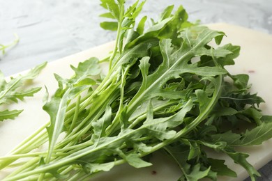 Photo of Fresh green arugula leaves on grey table, closeup