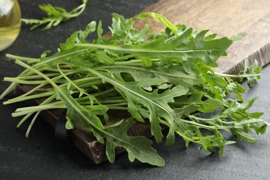 Photo of Fresh green arugula leaves on grey textured table, closeup