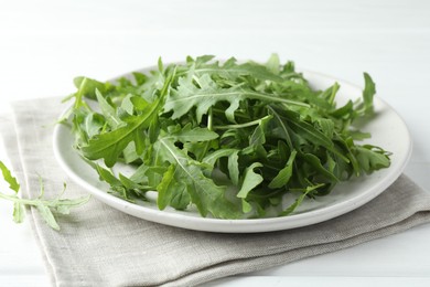 Photo of Fresh green arugula leaves on white table, closeup