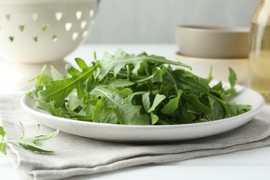 Photo of Fresh green arugula leaves on white table, closeup