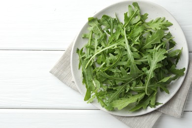 Photo of Fresh green arugula leaves on white wooden table, top view. Space for text