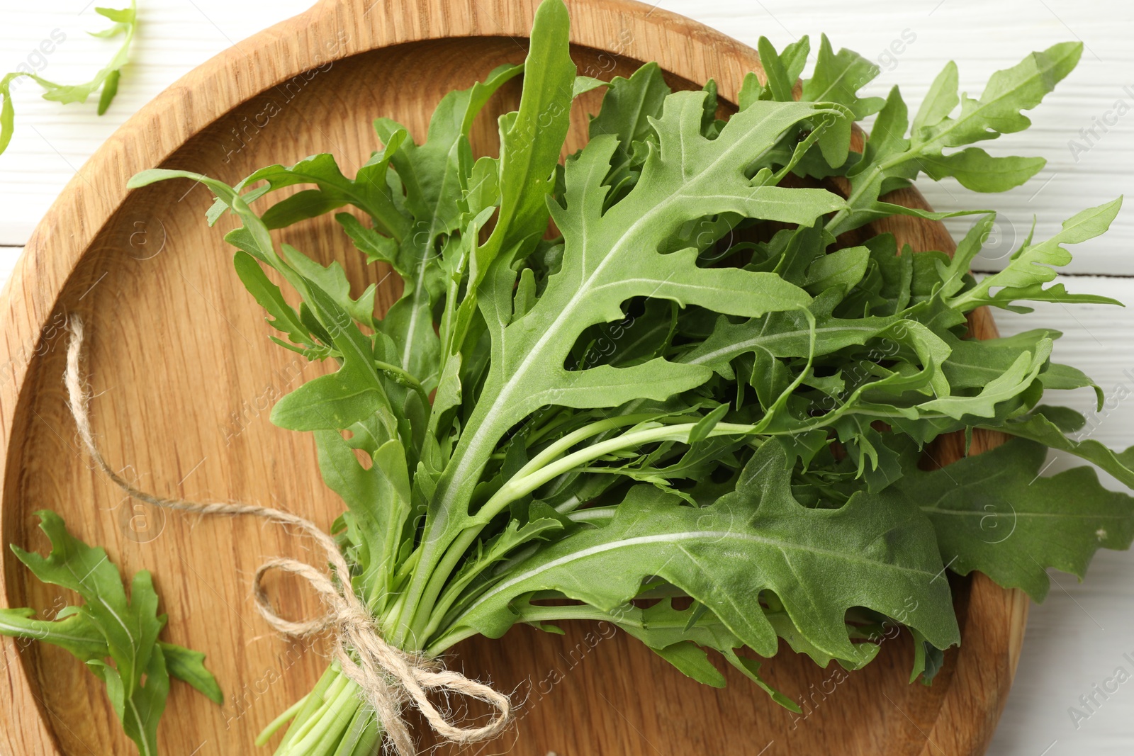 Photo of Bunch of fresh green arugula leaves on white table, top view