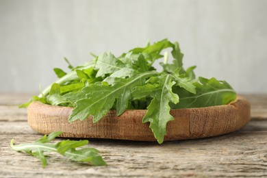 Photo of Fresh green arugula leaves on wooden table, closeup