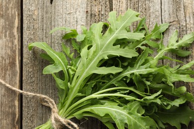 Photo of Bunch of fresh green arugula leaves on wooden table, top view