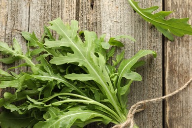 Photo of Bunch of fresh green arugula leaves on wooden table, top view