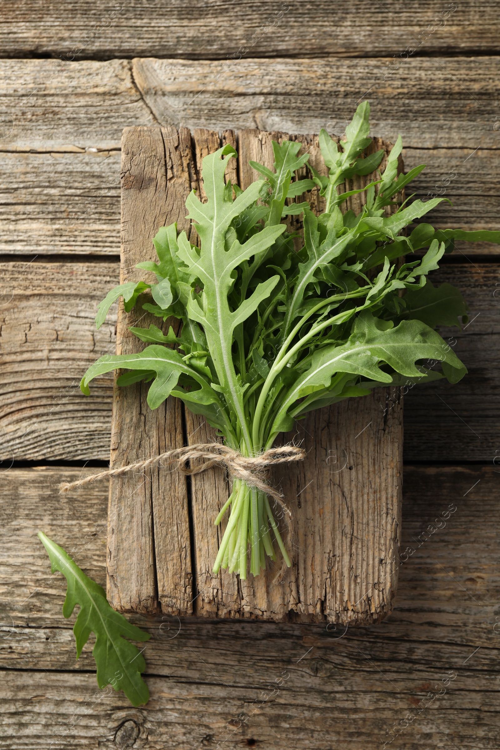 Photo of Bunch of fresh green arugula leaves on wooden table, top view