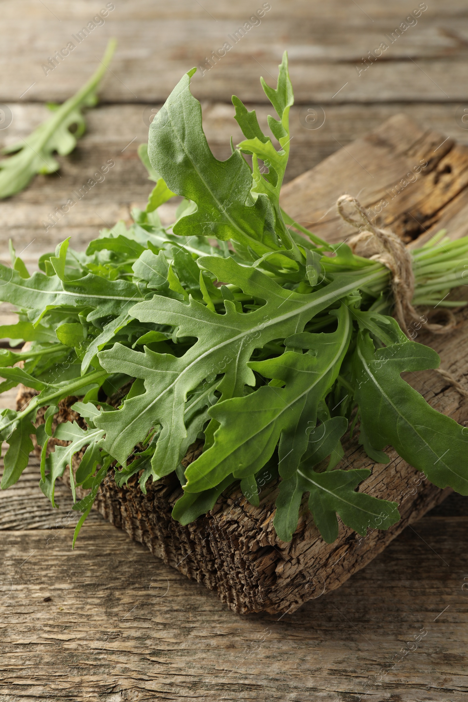 Photo of Bunch of fresh green arugula leaves on wooden table, closeup