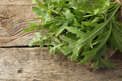 Photo of Fresh green arugula leaves on wooden table, closeup. Space for text