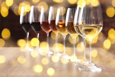 Image of Different tasty wines in glasses on table. Bokeh effect