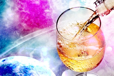 Image of Pouring white wine into glass against colorful sky, closeup. Space for text