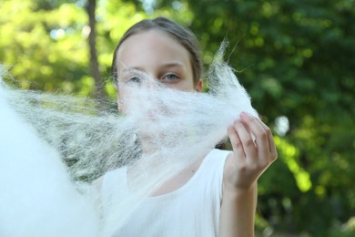 Little girl eating sweet cotton candy in park