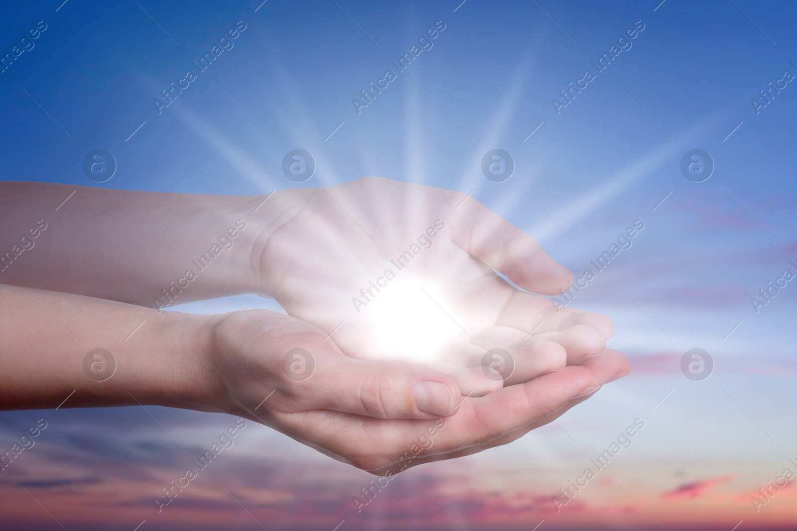 Image of Woman with holy light in hands against sky on sunrise, closeup