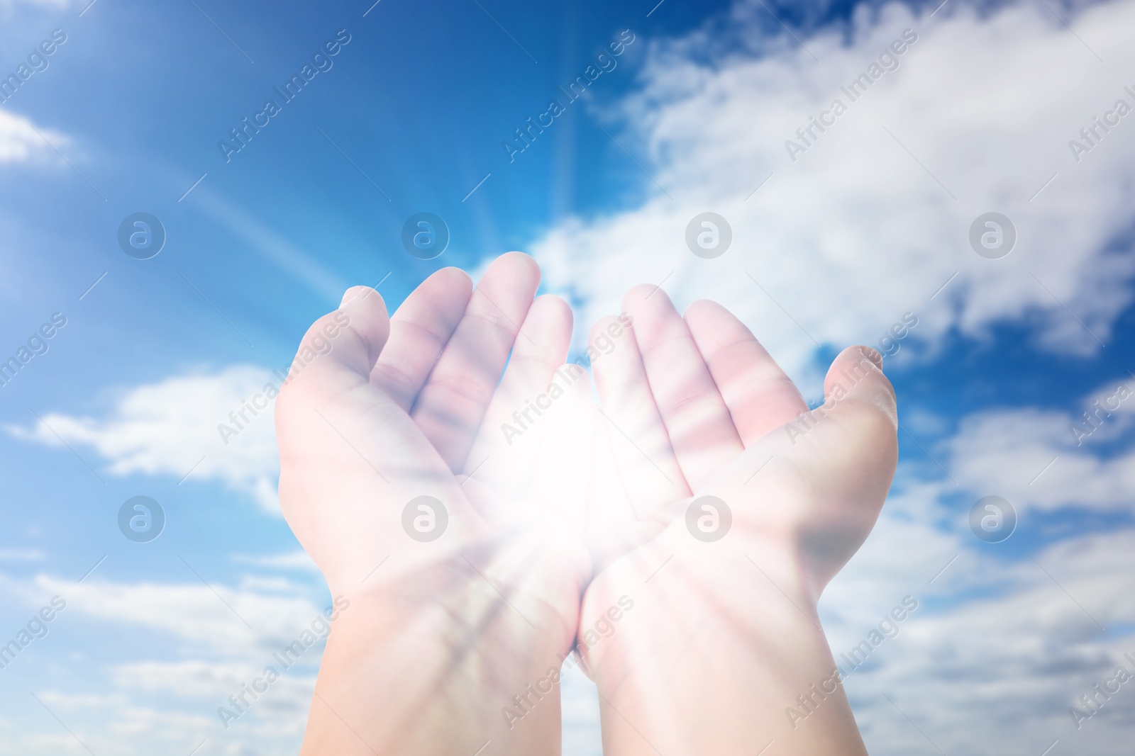 Image of Woman with holy light in hands against sky, closeup