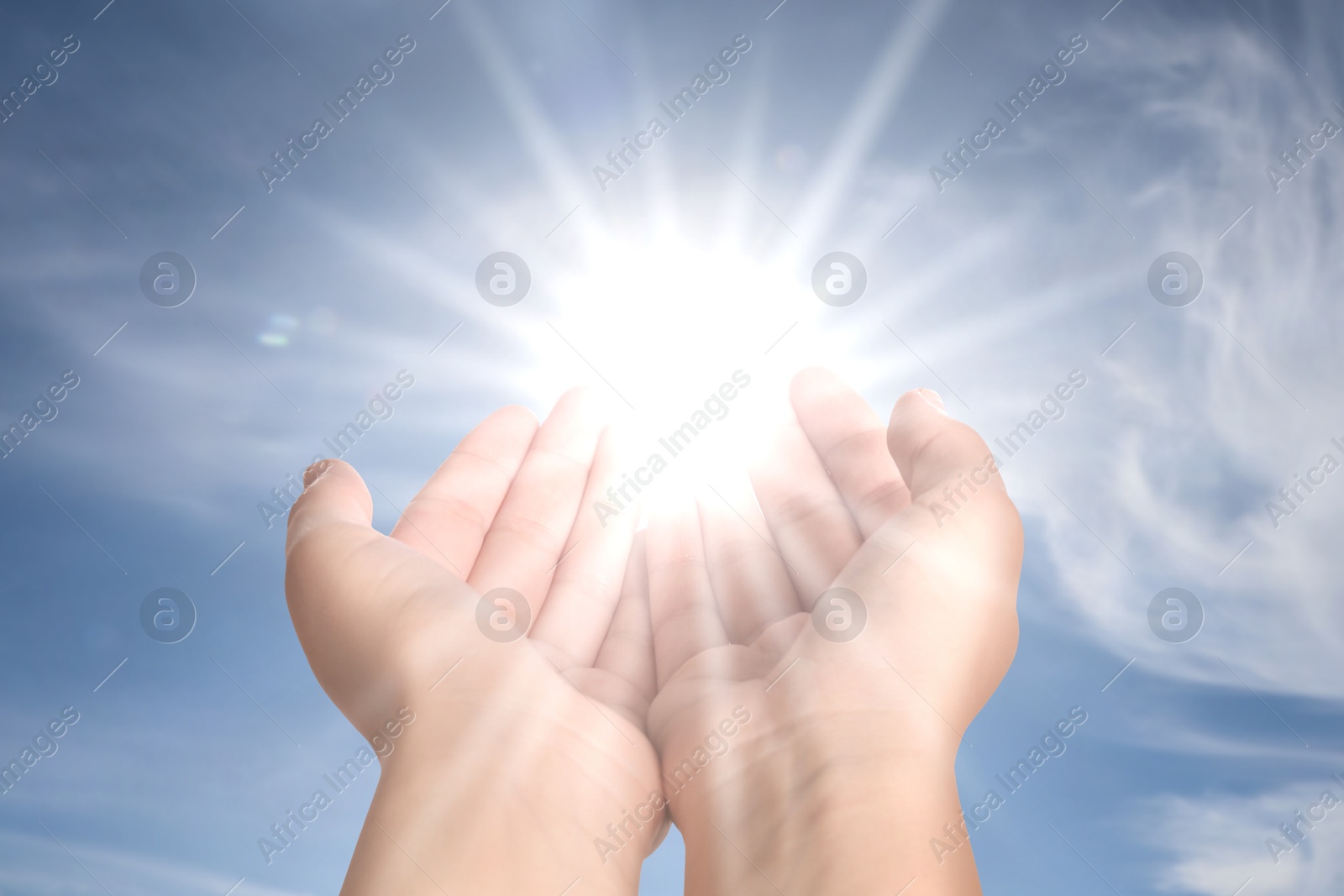 Image of Woman with holy light in hands against sky, closeup