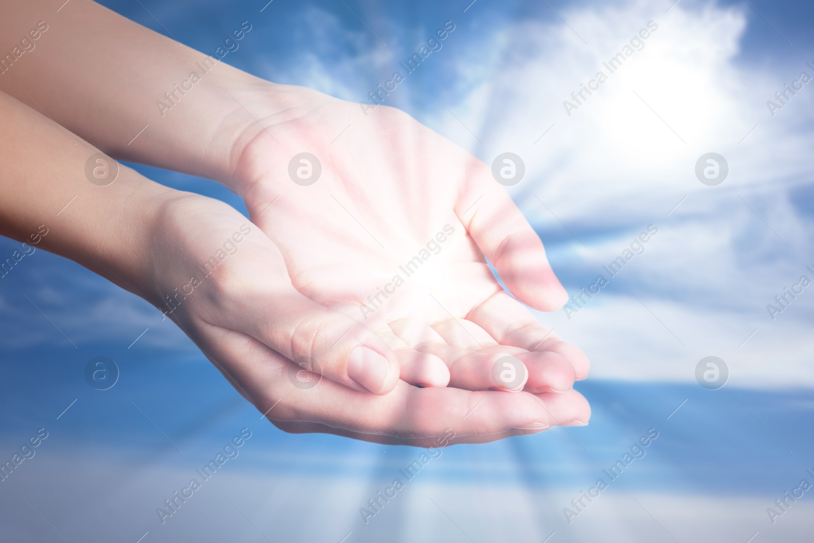 Image of Woman with holy light in hands against sky, closeup