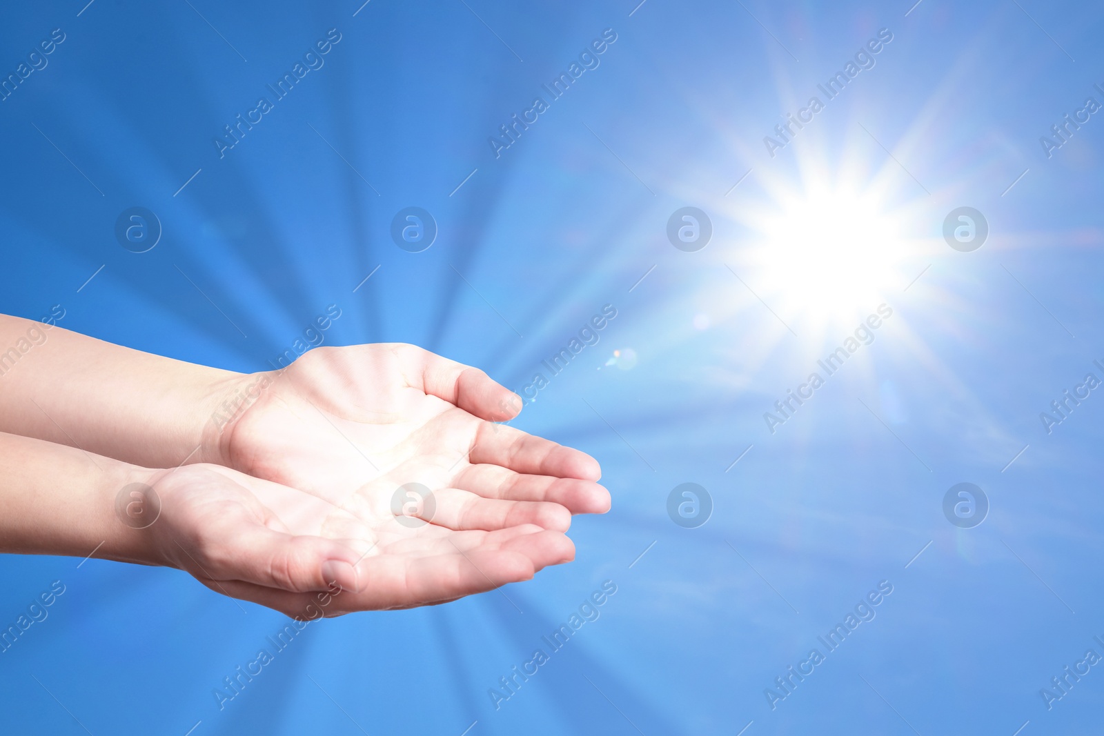 Image of Woman with holy light in hands against sky, closeup