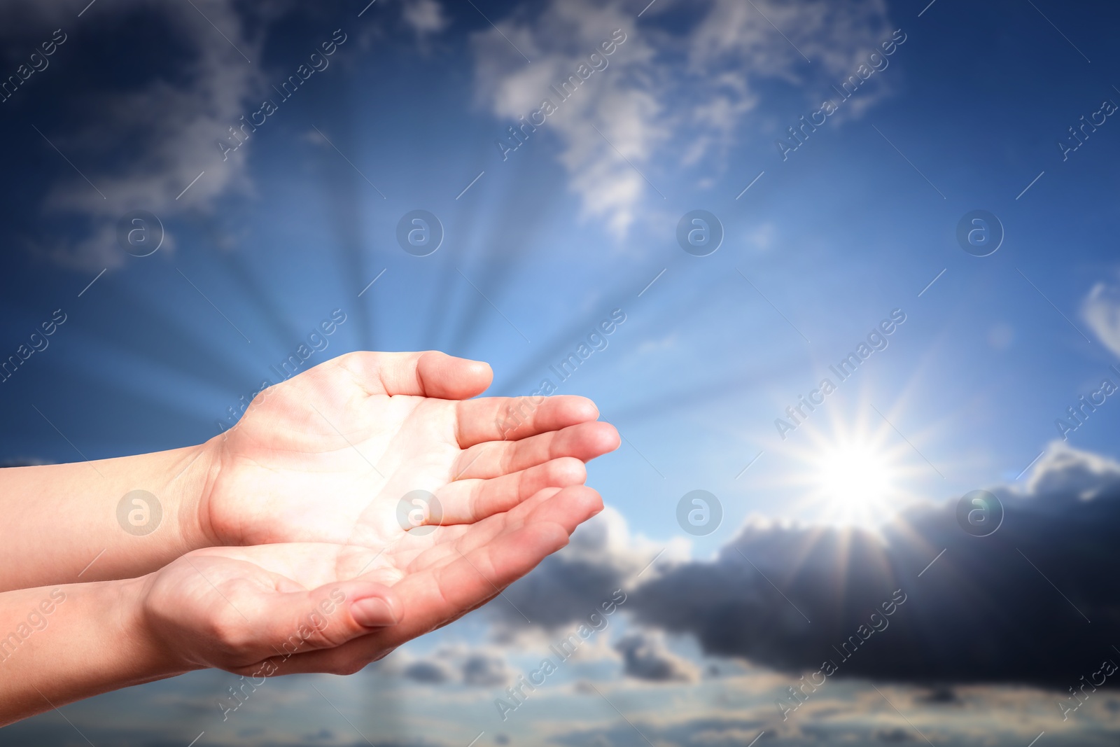 Image of Woman with holy light in hands against sky, closeup