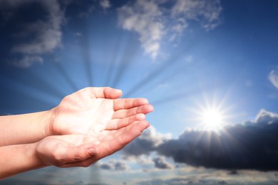 Image of Woman with holy light in hands against sky, closeup